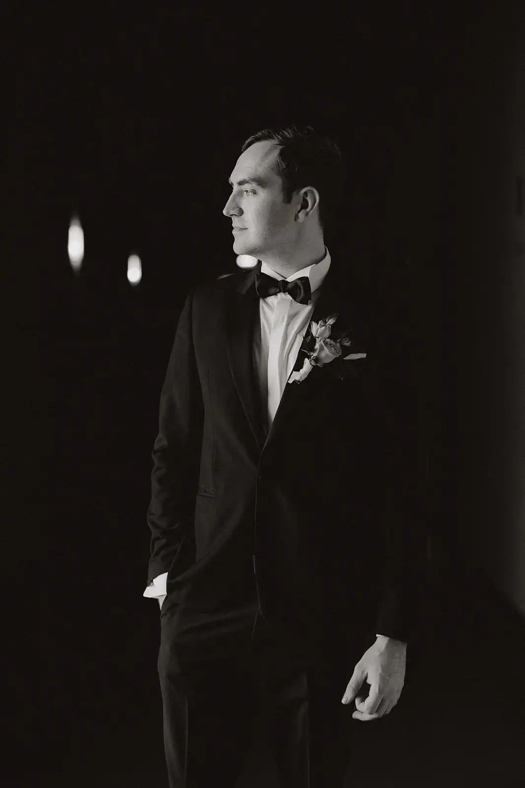 Black saturated photo of the groom with his face in profile instants before walking on the aisle