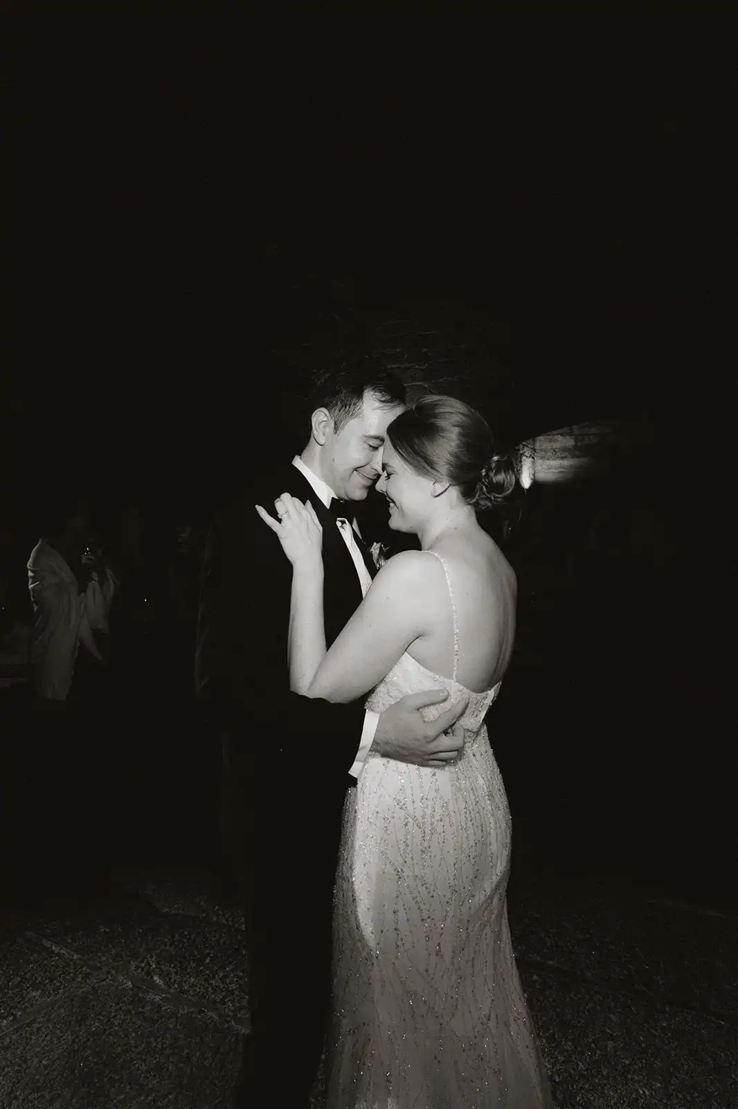 First dance moment in black and white with the bride and groom iluminated and the background all black.