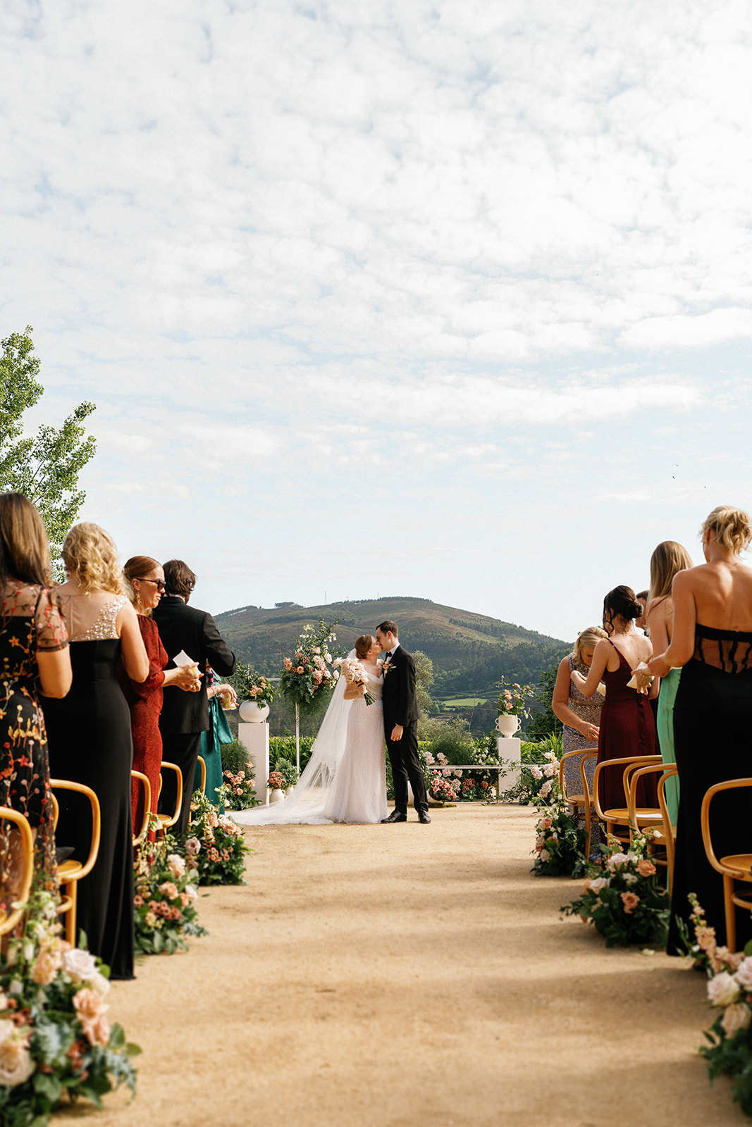 Moment of the bride and groom kiss during wedding ceremony, with the beautiful portuguese mountains as background.