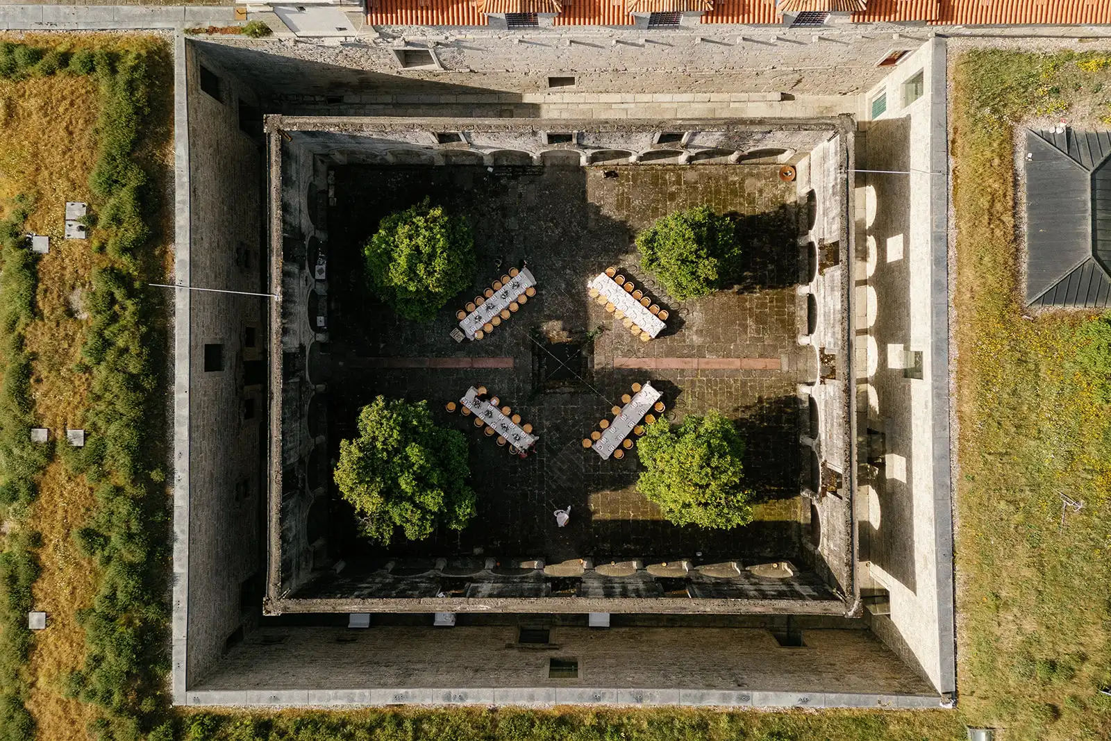 Aerial view from the cloisters of the Pousada Mosteiro de Amares, a old century venue in Portugal made by stones, with the wedding dinner setup assembled.