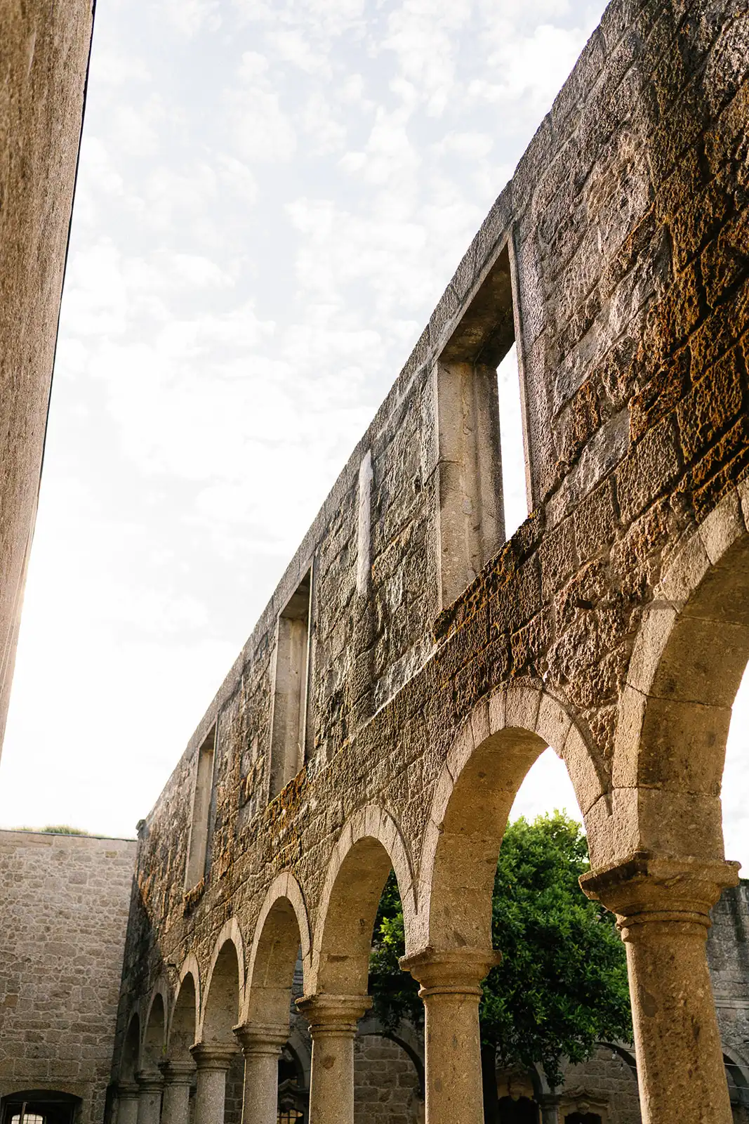 Architectural detail of the cloisters at the Pousada de Amares, featuring their centuries-old stone arches. View from the bottom looking up. Stunning wedding venue in Portugal.
