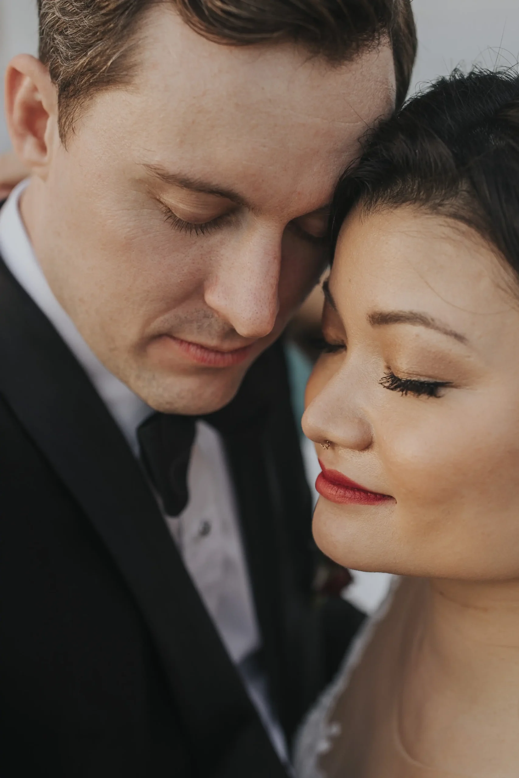 Close up of bride and groom with their faces pressed against each other. Asian bride.