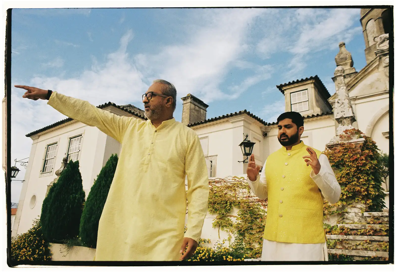 Indian wedding in Portugal. The moment before Haldi ceremony with groom and his father in yellow indian outfits and a portuguese historic country retreat as background.