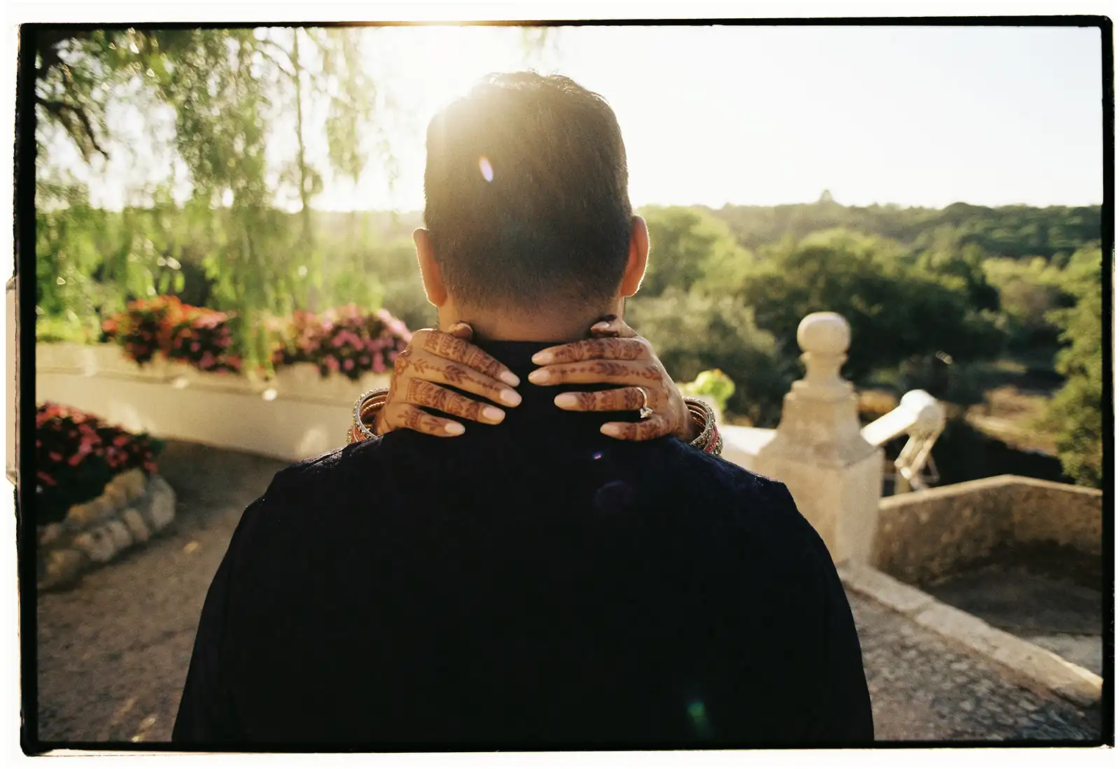 Indian couple in a portuguese landscape. bride's hands painted with henna