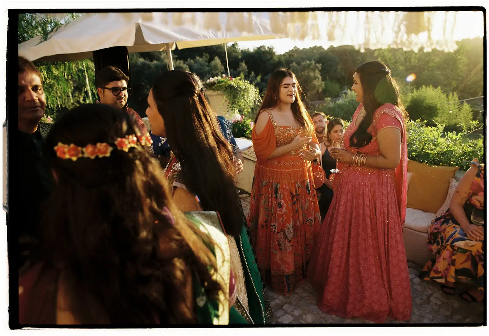 Indian wedding in Portugal during cocktail time at sunset. Guest talking and smiling.