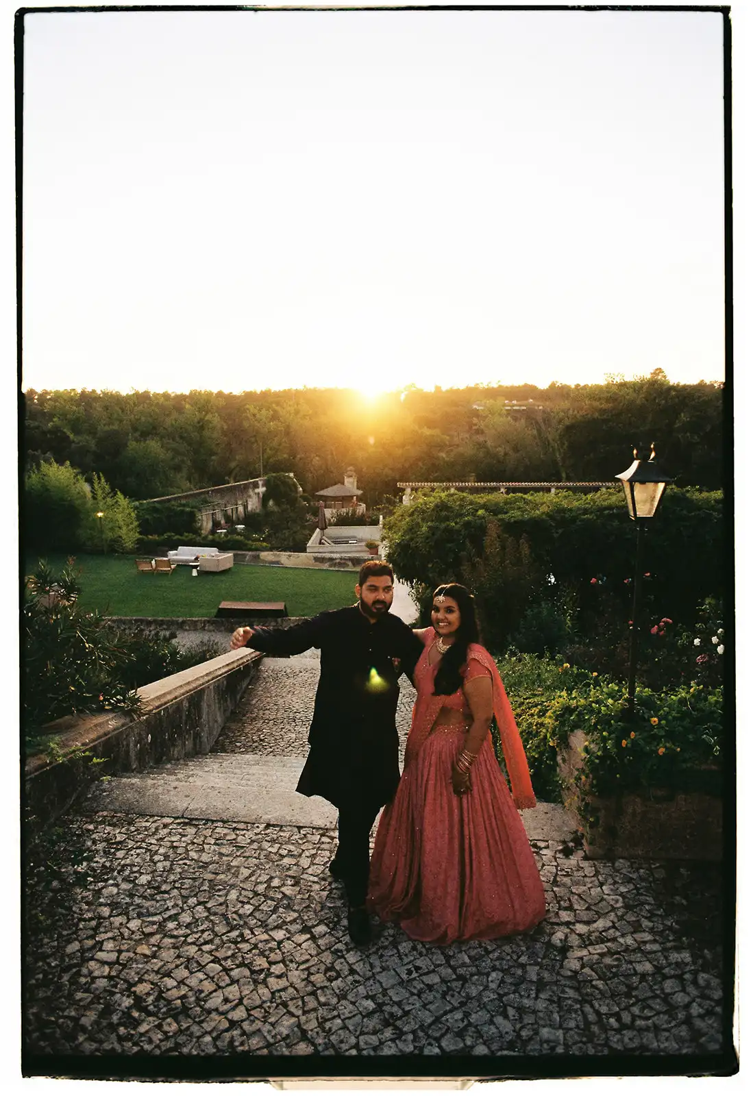Indian couple at sunset on a historic Portuguese country retreat. Sangeet night with black and pink outfits.