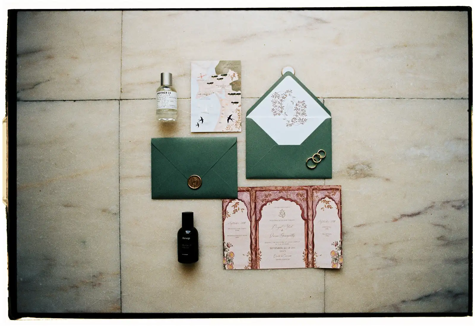 Indian wedding flat lay. Destination wedding stationary in pink and dark green.
