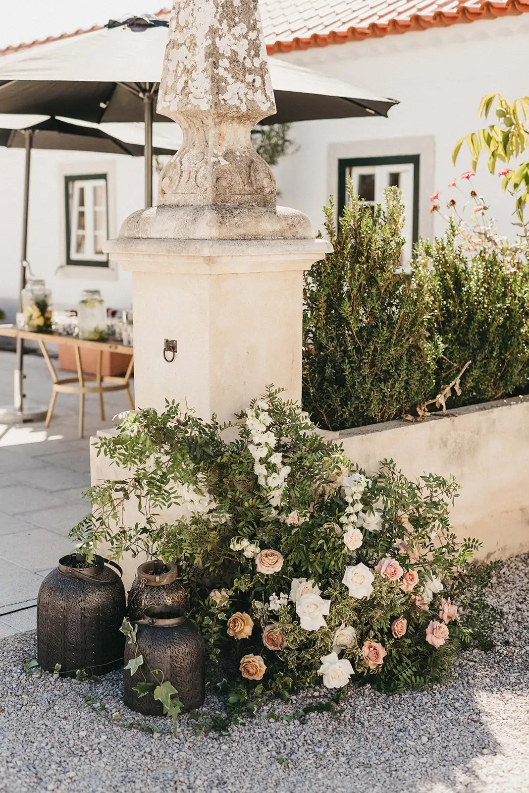 Ceremony entrance with neutral color flowers installation and morocan lanterns.